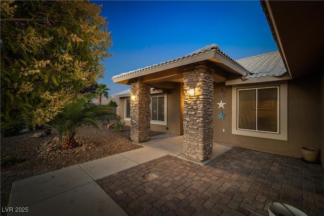 231 Bristle Cone, Pahrump, NV 89048 - view of side of home featuring stucco siding, a patio area, and a tile roof