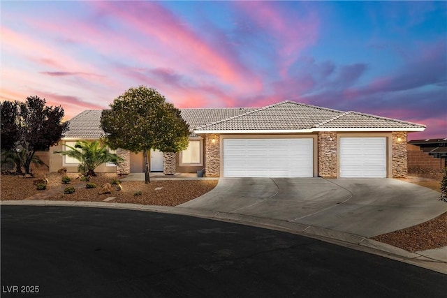 231 Bristle Cone, Pahrump, NV 89048 - view of front of home featuring a tile roof, stone siding, concrete driveway, a garage, and stucco siding