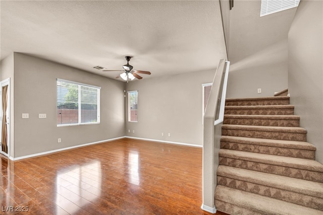3757 Via Geneva, Henderson, NV 89052 - unfurnished living room featuring a ceiling fan, wood finished floors, stairs, and a textured ceiling