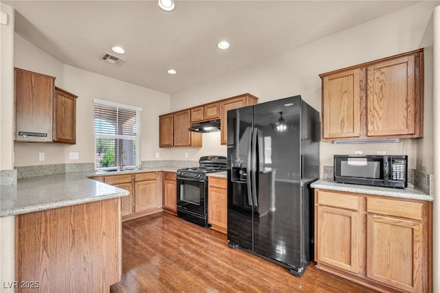 3757 Via Geneva, Henderson, NV 89052 - kitchen featuring black appliances, under cabinet range hood, wood finished floors, recessed lighting, and a peninsula