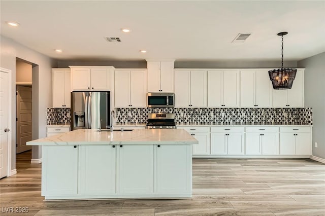 5990 Viscaya Grove St, Las Vegas, NV 89118 - kitchen featuring stainless steel appliances, white cabinets, a kitchen island with sink, decorative backsplash, and recessed lighting