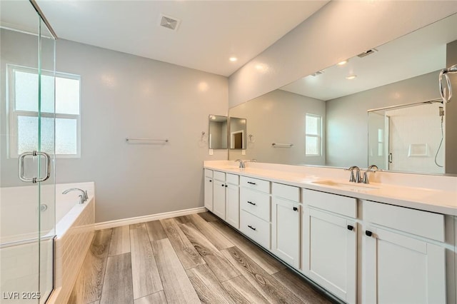 5990 Viscaya Grove St, Las Vegas, NV 89118 - bathroom with double vanity, a bath, wood finished floors, a shower stall, and recessed lighting