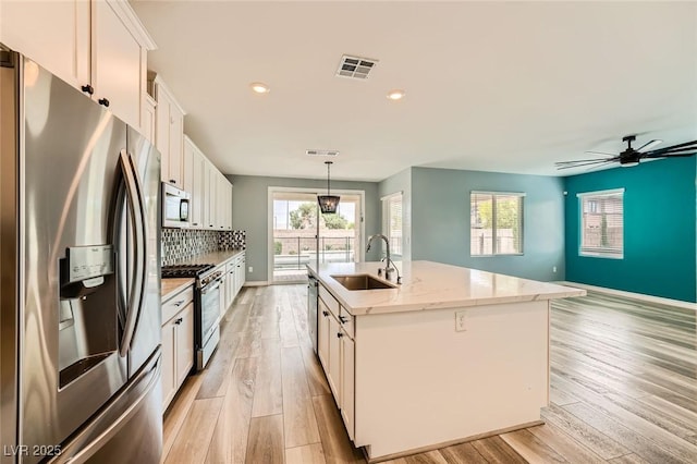 5990 Viscaya Grove St, Las Vegas, NV 89118 - kitchen with appliances with stainless steel finishes, white cabinetry, an island with sink, light wood-style flooring, and recessed lighting
