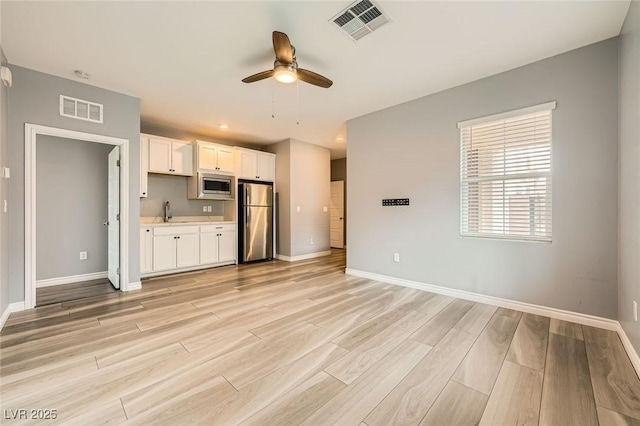 5990 Viscaya Grove St, Las Vegas, NV 89118 - kitchen with appliances with stainless steel finishes, a ceiling fan, white cabinets, light wood-style flooring, and light countertops