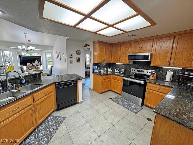 4910 Marywood Ct, Pahrump, NV 89061 - kitchen with stainless steel appliances, brown cabinets, a chandelier, backsplash, and light tile patterned floors