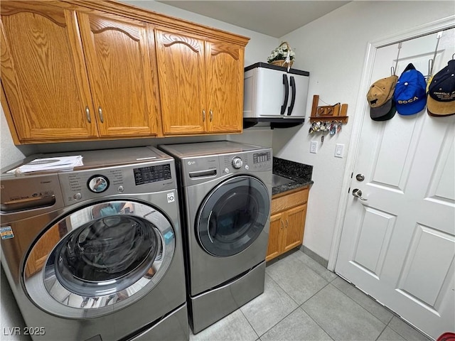 4910 Marywood Ct, Pahrump, NV 89061 - laundry area featuring washing machine and clothes dryer, cabinet space, and light tile patterned floors