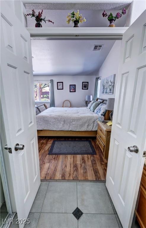 4910 Marywood Ct, Pahrump, NV 89061 - bedroom with light tile patterned floors and vaulted ceiling