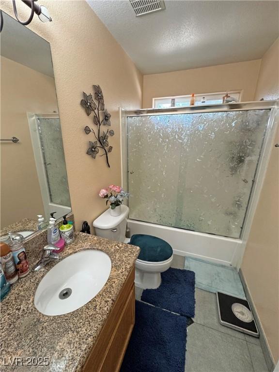 4910 Marywood Ct, Pahrump, NV 89061 - full bath featuring vanity, combined bath / shower with glass door, a textured ceiling, and tile patterned flooring