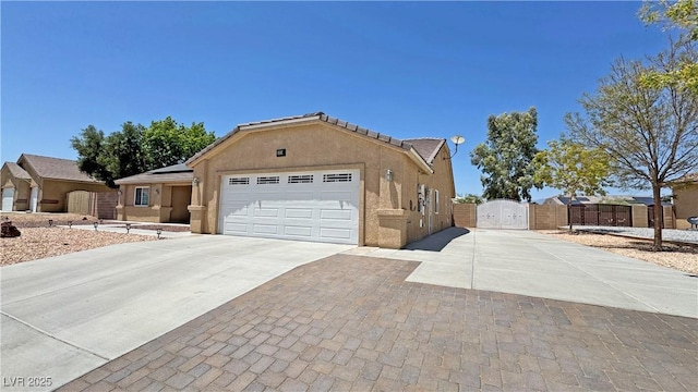 4910 Marywood Ct, Pahrump, NV 89061 - view of front of home with a gate, concrete driveway, a garage, stucco siding, and roof mounted solar panels