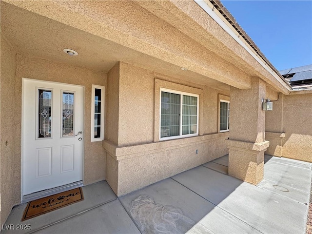 4910 Marywood Ct, Pahrump, NV 89061 - property entrance with stucco siding, a patio area, and solar panels