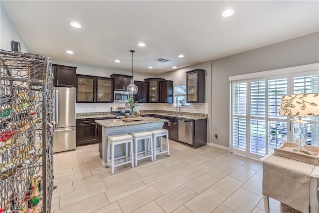 9113 Sea Mink Ave, Las Vegas, NV 89149 - kitchen featuring appliances with stainless steel finishes, dark brown cabinets, backsplash, a breakfast bar, and recessed lighting