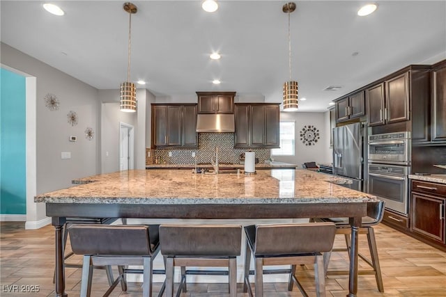 2154 Tortona St, Henderson, NV 89044 - kitchen featuring under cabinet range hood, decorative backsplash, stainless steel appliances, dark brown cabinets, and recessed lighting