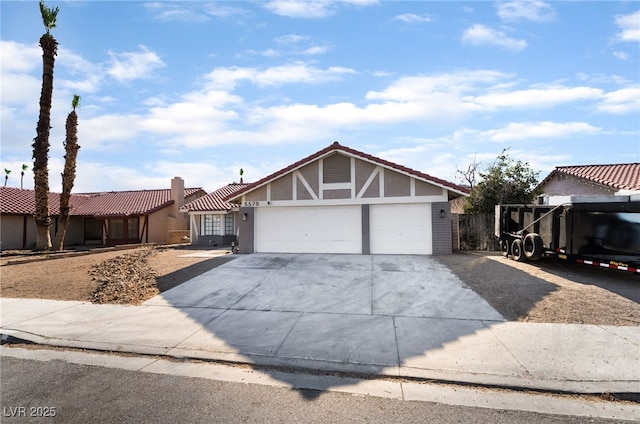 5570 Palm St, Las Vegas, NV 89120 - view of front of house featuring an attached garage, a tiled roof, concrete driveway, and stucco siding