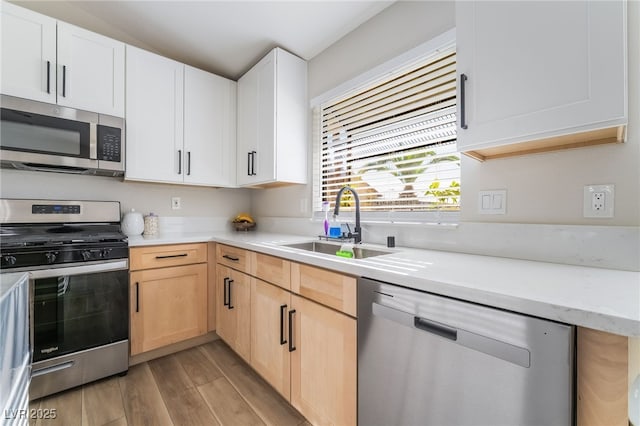 5570 Palm St, Las Vegas, NV 89120 - kitchen featuring appliances with stainless steel finishes, light wood-style flooring, light brown cabinetry, and white cabinetry