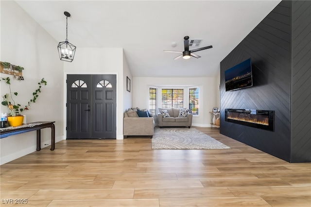 5570 Palm St, Las Vegas, NV 89120 - entryway with a ceiling fan, a fireplace, light wood-style floors, and vaulted ceiling