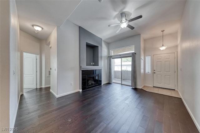 8805 Jeffreys St Unit 1048, Las Vegas, NV 89123 - unfurnished living room with dark wood-type flooring, a fireplace, and a ceiling fan
