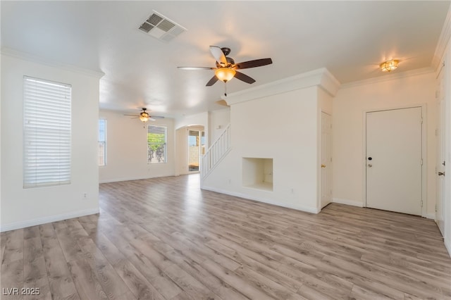 2400 Dutchmans Pipe Ct, Las Vegas, NV 89106 - unfurnished living room with ceiling fan, arched walkways, ornamental molding, light wood-type flooring, and stairs
