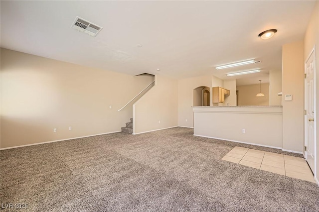 8842 Duncan Barrel Ave Unit 103, Las Vegas, NV 89178 - unfurnished living room with carpet, arched walkways, and stairway