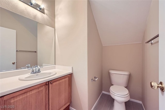 8842 Duncan Barrel Ave Unit 103, Las Vegas, NV 89178 - half bathroom featuring vaulted ceiling, vanity, and wood finished floors