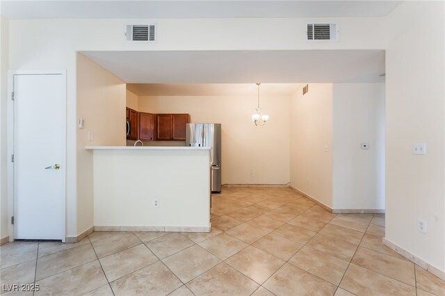 2141 Hussium Hills St Unit 108, Las Vegas, NV 89108 - kitchen featuring freestanding refrigerator, a chandelier, decorative light fixtures, and light tile patterned flooring