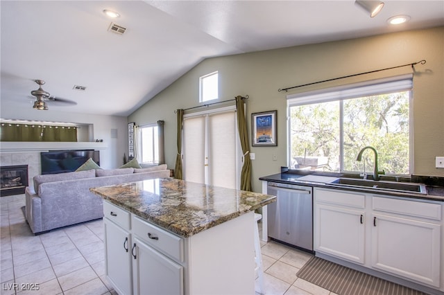 1844 Ghost Trace Ave, Las Vegas, NV 89183 - kitchen featuring dishwasher, vaulted ceiling, light tile patterned floors, a kitchen island, and white cabinetry