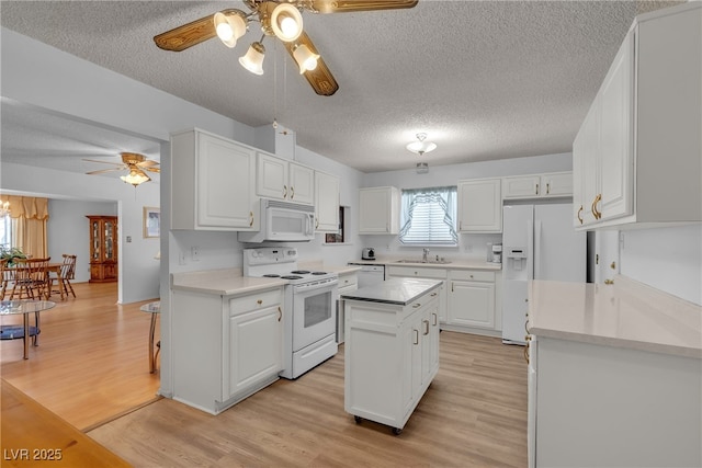 909 Biljac St, Las Vegas, NV 89145 - kitchen with white appliances, ceiling fan, a textured ceiling, white cabinetry, and light wood finished floors