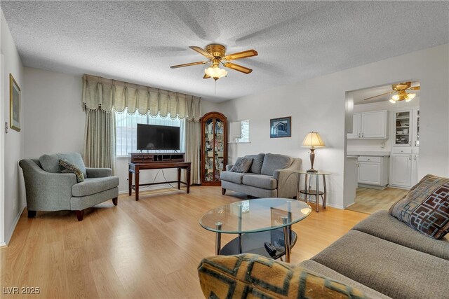 909 Biljac St, Las Vegas, NV 89145 - living room with ceiling fan, light wood finished floors, and a textured ceiling