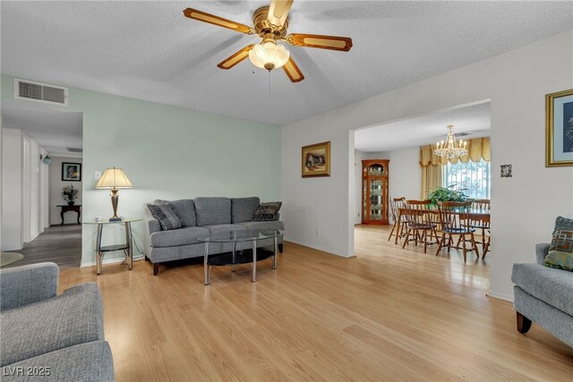 909 Biljac St, Las Vegas, NV 89145 - living room featuring light wood-type flooring, a chandelier, a textured ceiling, and ceiling fan