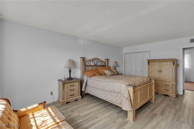 909 Biljac St, Las Vegas, NV 89145 - bedroom with light wood-style flooring, a textured ceiling, and a closet