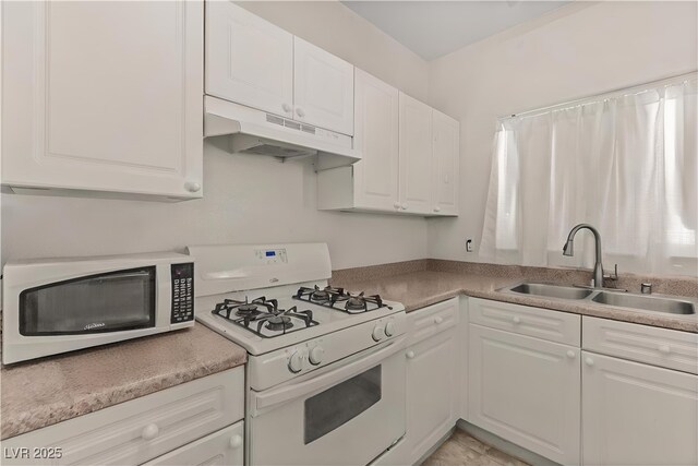 8843 Tomnitz Ave Unit 102, Las Vegas, NV 89178 - kitchen featuring white appliances, under cabinet range hood, white cabinetry, and light countertops