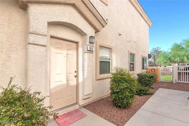 8843 Tomnitz Ave Unit 102, Las Vegas, NV 89178 - doorway to property with a gate and stucco siding