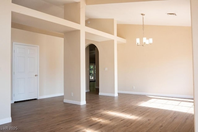 904 Swift Bear St, Henderson, NV 89002 - unfurnished room with arched walkways, a chandelier, wood finished floors, and high vaulted ceiling