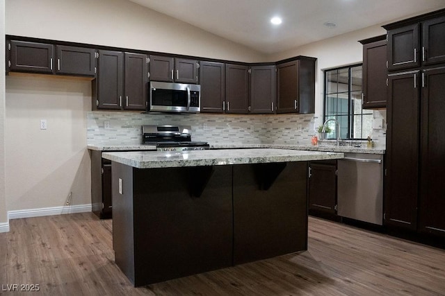904 Swift Bear St, Henderson, NV 89002 - kitchen featuring stainless steel appliances, tasteful backsplash, dark wood-style flooring, a center island, and vaulted ceiling