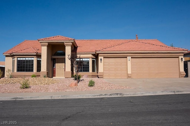 904 Swift Bear St, Henderson, NV 89002 - view of front of house featuring an attached garage, a tile roof, concrete driveway, and stucco siding