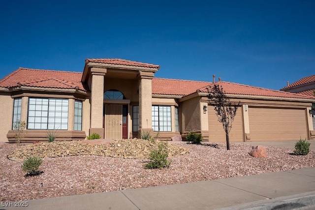 904 Swift Bear St, Henderson, NV 89002 - view of front facade with a tiled roof, a garage, stucco siding, and driveway
