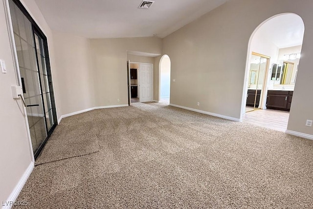 904 Swift Bear St, Henderson, NV 89002 - empty room featuring arched walkways, light colored carpet, and vaulted ceiling