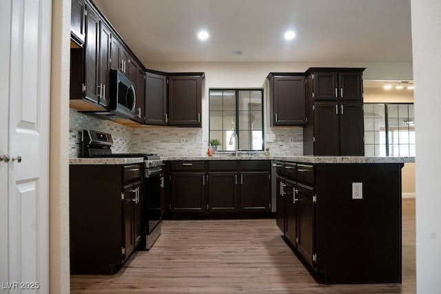 904 Swift Bear St, Henderson, NV 89002 - kitchen with stainless steel appliances, decorative backsplash, wood finished floors, light stone counters, and recessed lighting