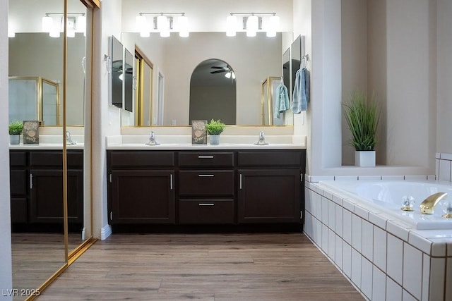 904 Swift Bear St, Henderson, NV 89002 - full bath with double vanity, a bath, wood finished floors, and a shower with door