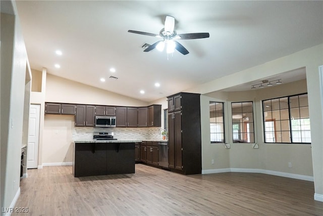 904 Swift Bear St, Henderson, NV 89002 - kitchen featuring appliances with stainless steel finishes, a center island, light wood finished floors, decorative backsplash, and lofted ceiling