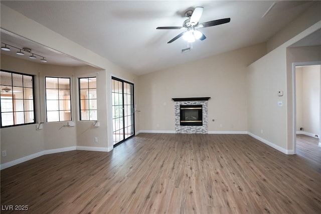 904 Swift Bear St, Henderson, NV 89002 - unfurnished living room featuring wood finished floors, a stone fireplace, ceiling fan, and lofted ceiling