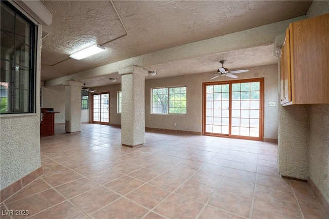 904 Swift Bear St, Henderson, NV 89002 - unfurnished living room with ceiling fan, light tile patterned floors, ornate columns, and a textured ceiling