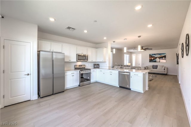 187 Palm Fox Ct, Henderson, NV 89011 - kitchen with stainless steel appliances, open floor plan, a peninsula, white cabinets, and recessed lighting