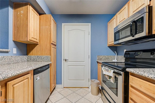 5055 W Hacienda Ave Unit 2003, Las Vegas, NV 89118 - kitchen featuring appliances with stainless steel finishes, light brown cabinets, light tile patterned floors, light stone countertops, and a textured ceiling