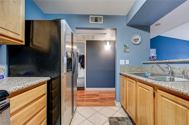 5055 W Hacienda Ave Unit 2003, Las Vegas, NV 89118 - kitchen featuring stainless steel fridge, light tile patterned floors, light brown cabinetry, and stove