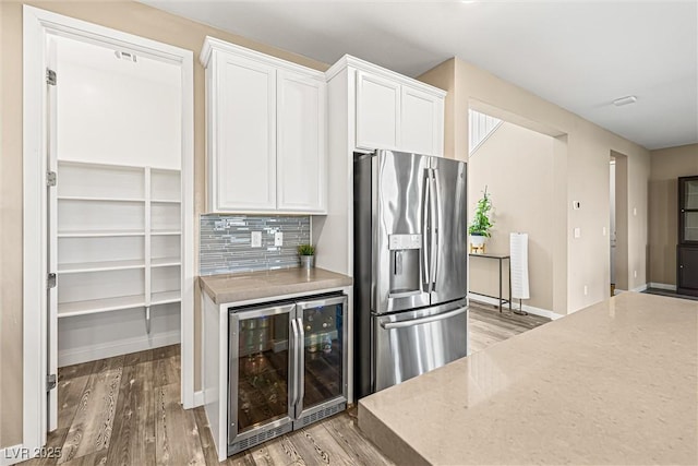 12415 Notch Trail Ave, Las Vegas, NV 89138 - kitchen featuring stainless steel refrigerator with ice dispenser, beverage cooler, light wood finished floors, and white cabinetry