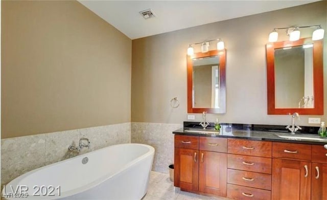 4525 Dean Martin Dr Unit 2203, Las Vegas, NV 89103 - bathroom featuring double vanity, a freestanding tub, and wainscoting
