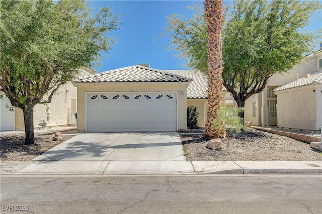6009 Flowering Plum Ave, Las Vegas, NV 89142 - mediterranean / spanish-style home with a tile roof, driveway, stucco siding, and an attached garage