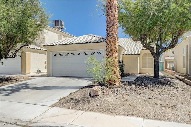 6009 Flowering Plum Ave, Las Vegas, NV 89142 - view of front of house with a tiled roof, a garage, driveway, and stucco siding