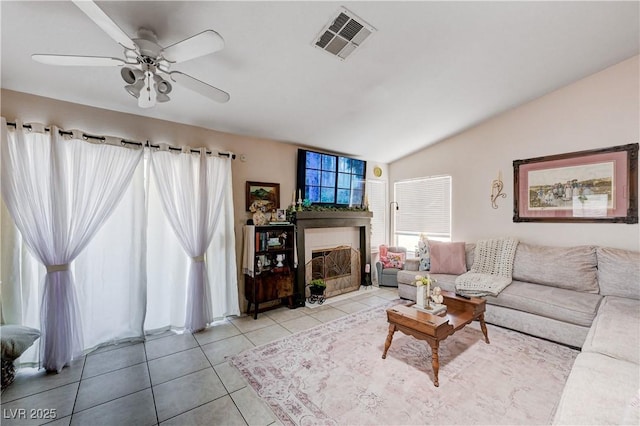 6009 Flowering Plum Ave, Las Vegas, NV 89142 - living room featuring vaulted ceiling, a fireplace with flush hearth, light tile patterned flooring, and ceiling fan