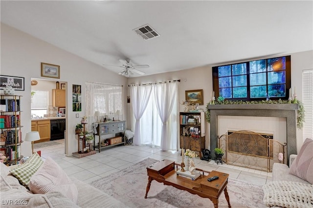 6009 Flowering Plum Ave, Las Vegas, NV 89142 - living room featuring light tile patterned flooring, a ceiling fan, a tile fireplace, and vaulted ceiling